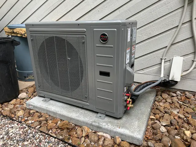 New Ruud condenser set on a fresh concrete pad